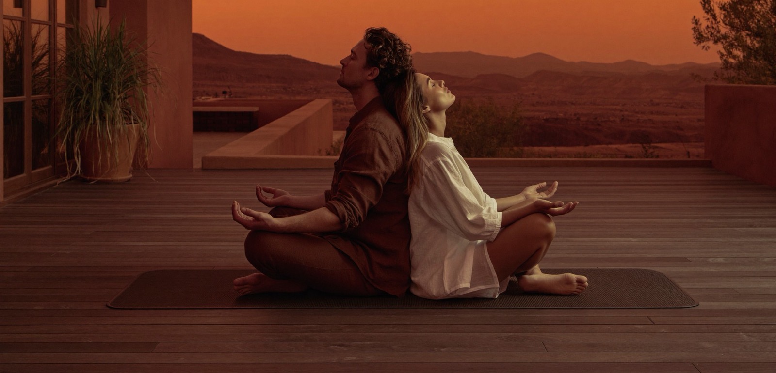 A couple meditating together at sunset, present and at ease